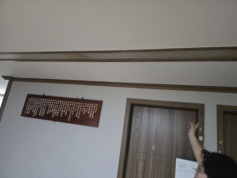 빌라 현관 앞 천장 몰딩을 따라 번진 물자국을 손으로 가리키며 확인하는 모습